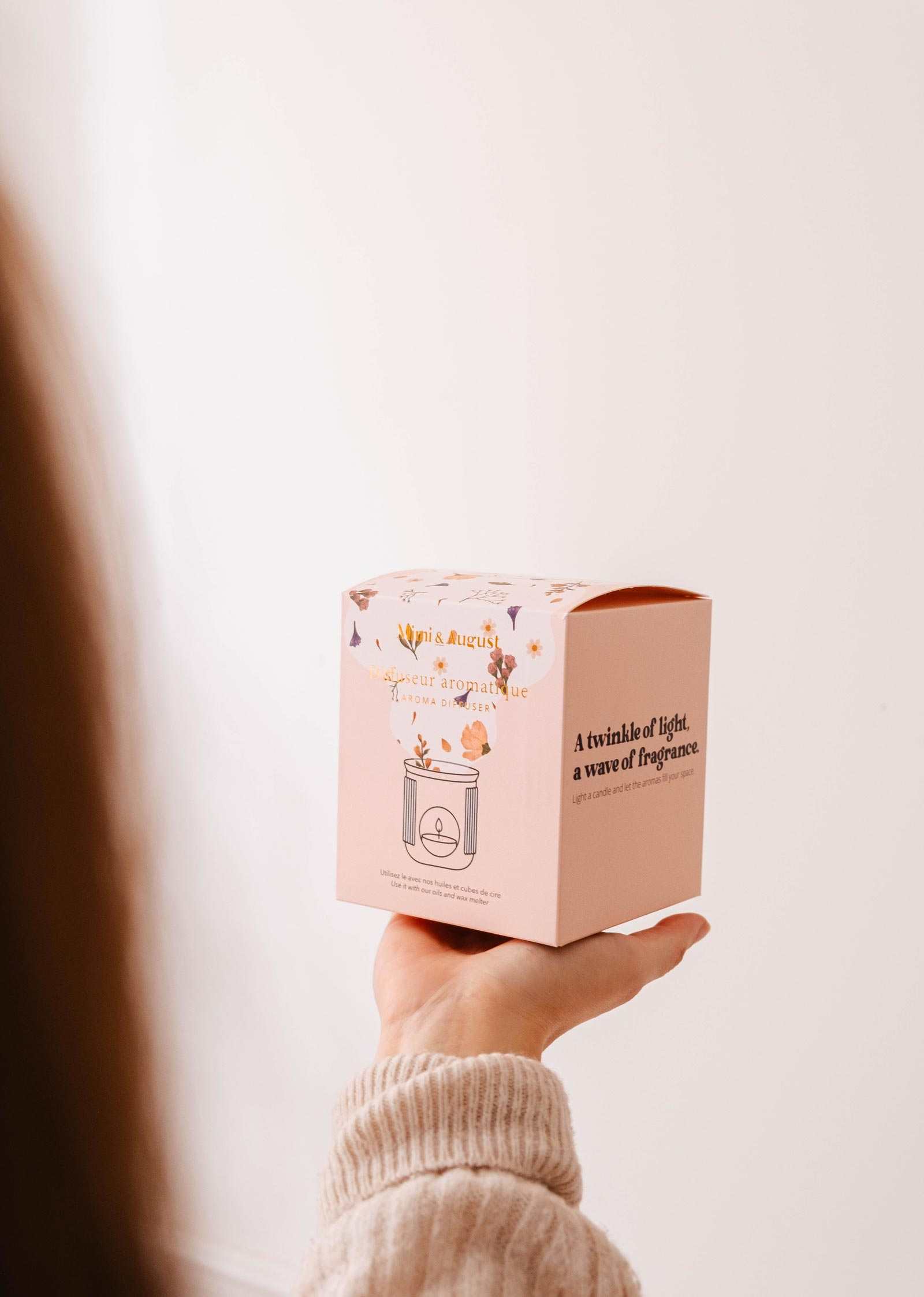 Hand holding a pink box Mimi and August ceramic diffuser