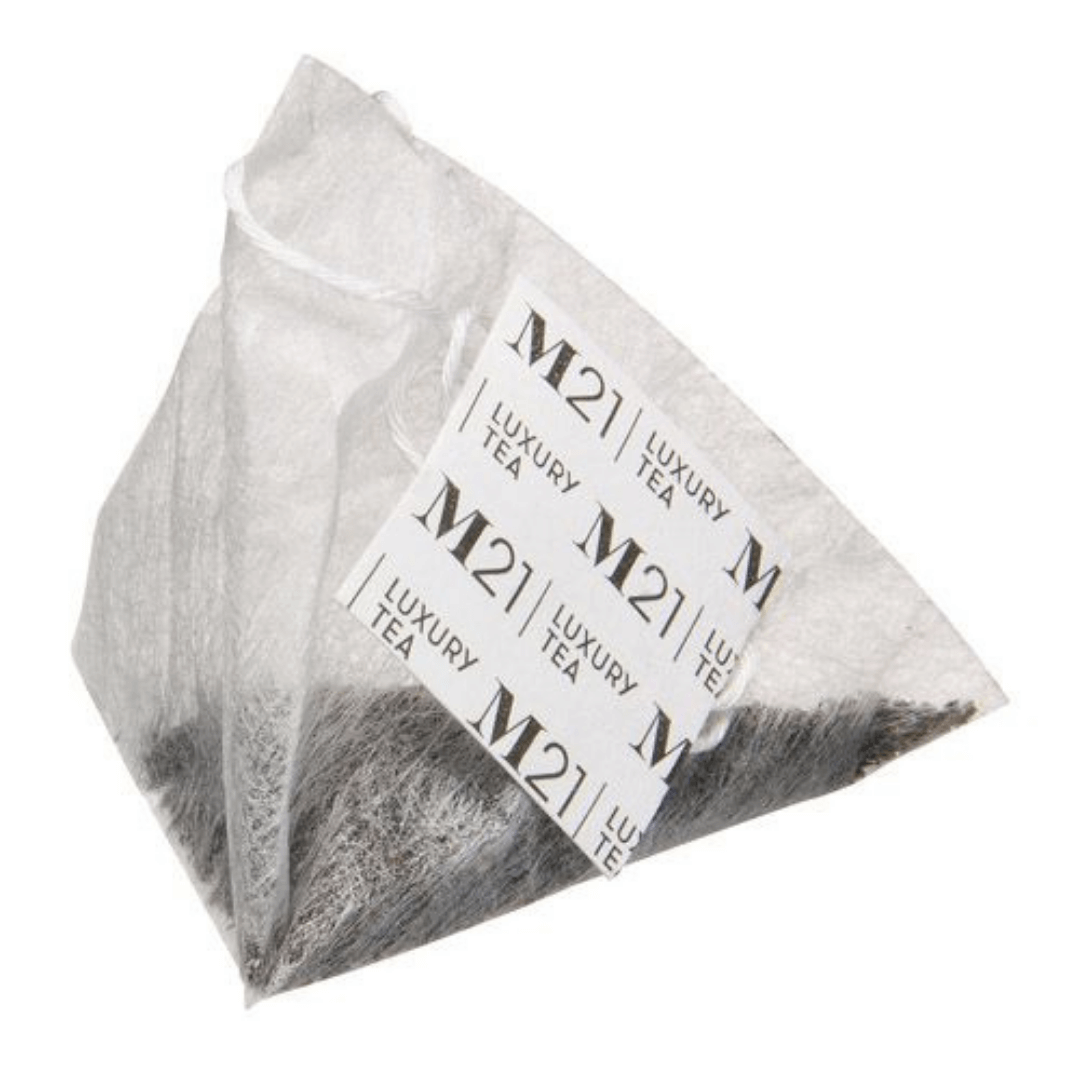M21 Maple Golden Cream luxury tea bag in a pyramid shape, made from compostable material, showcasing whole leaf black tea.