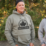 Man wearing a 'Made in Canada' hoodie standing outdoors with trees in the background