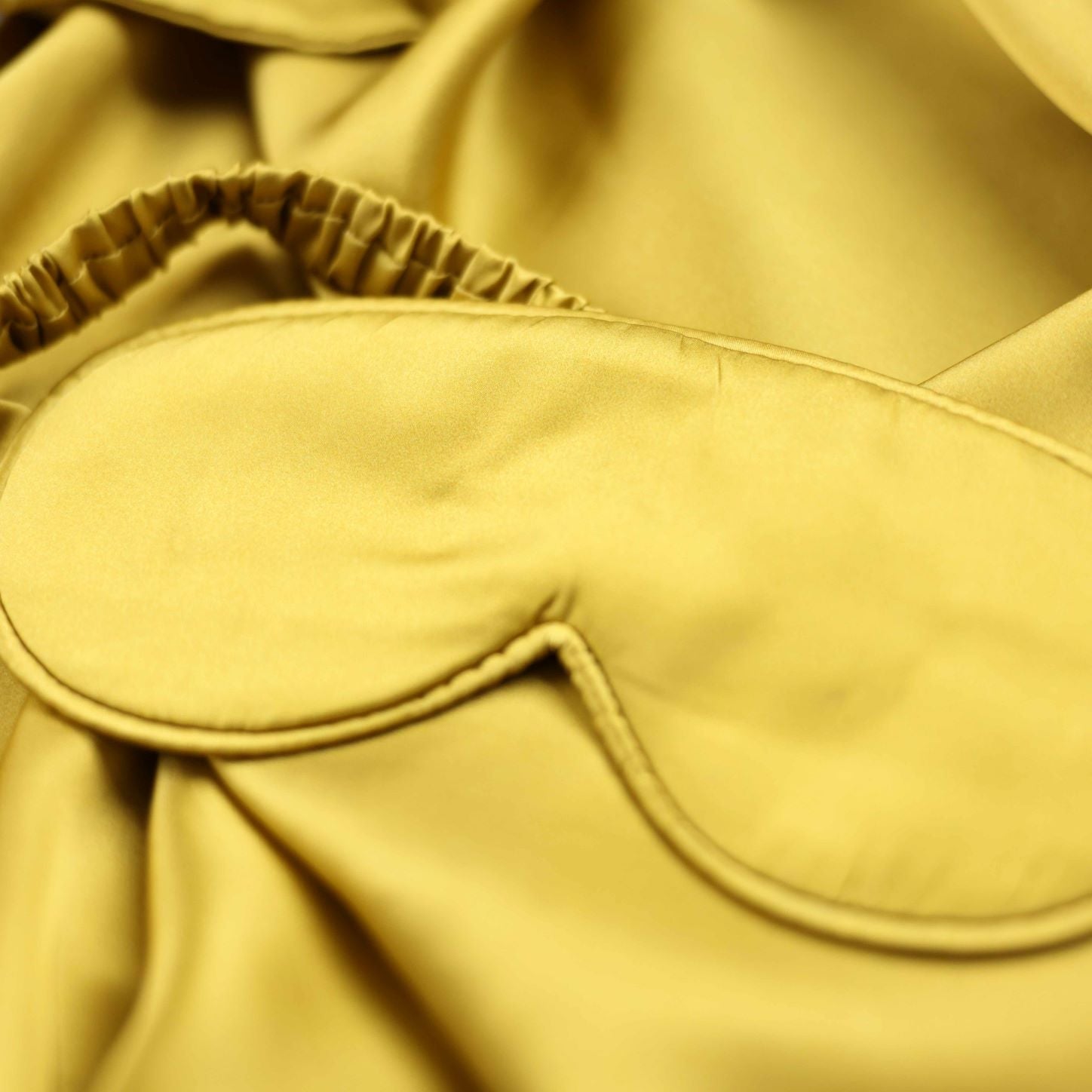 Yellow sleep mask on a yellow fabric background