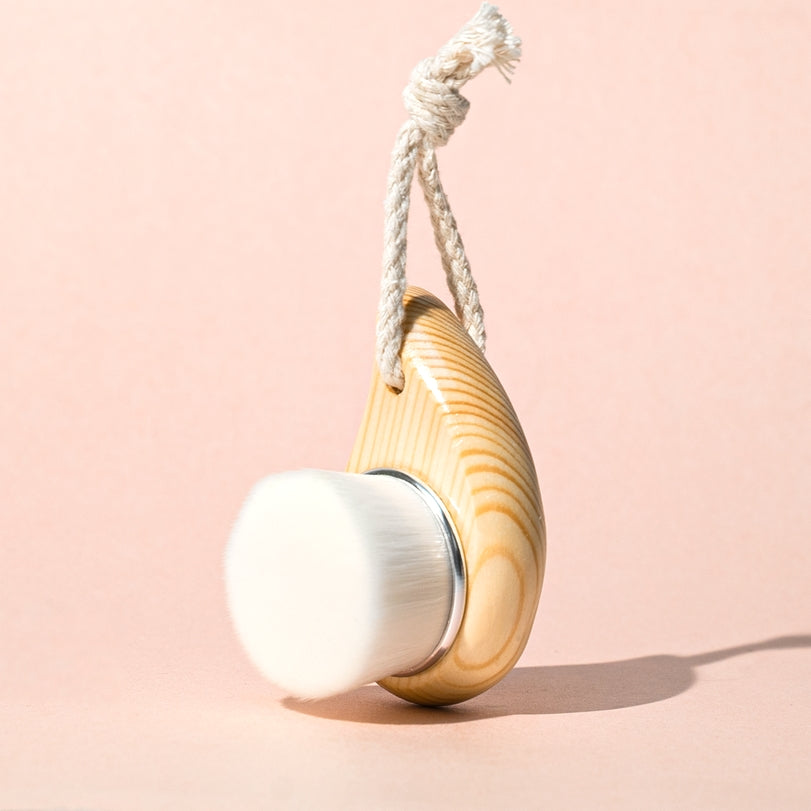 Vegan dry facial brush with soft bristles and wooden handle, ideal for gentle exfoliation and boosting circulation.