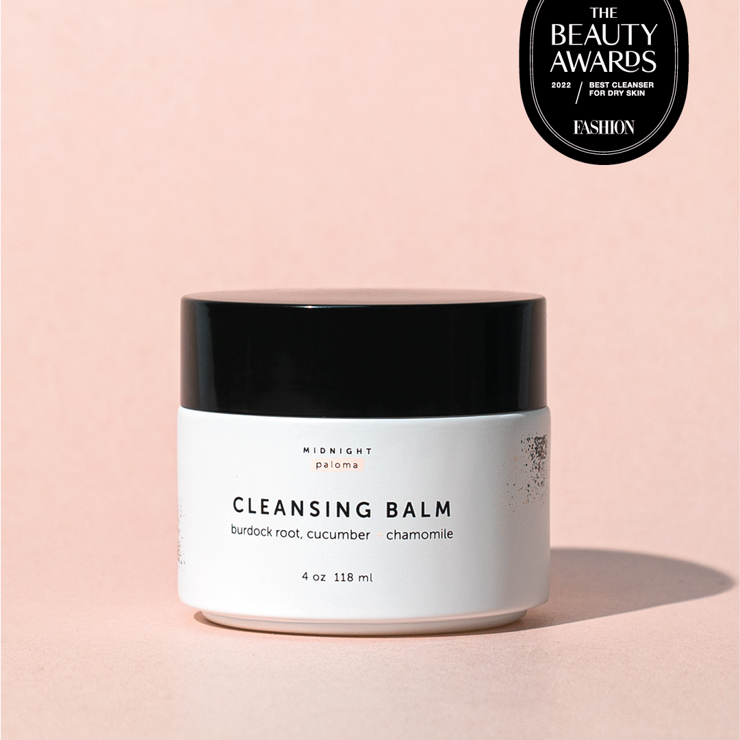 Cleansing balm jar with 'The Beauty Awards' badge on a pink background
