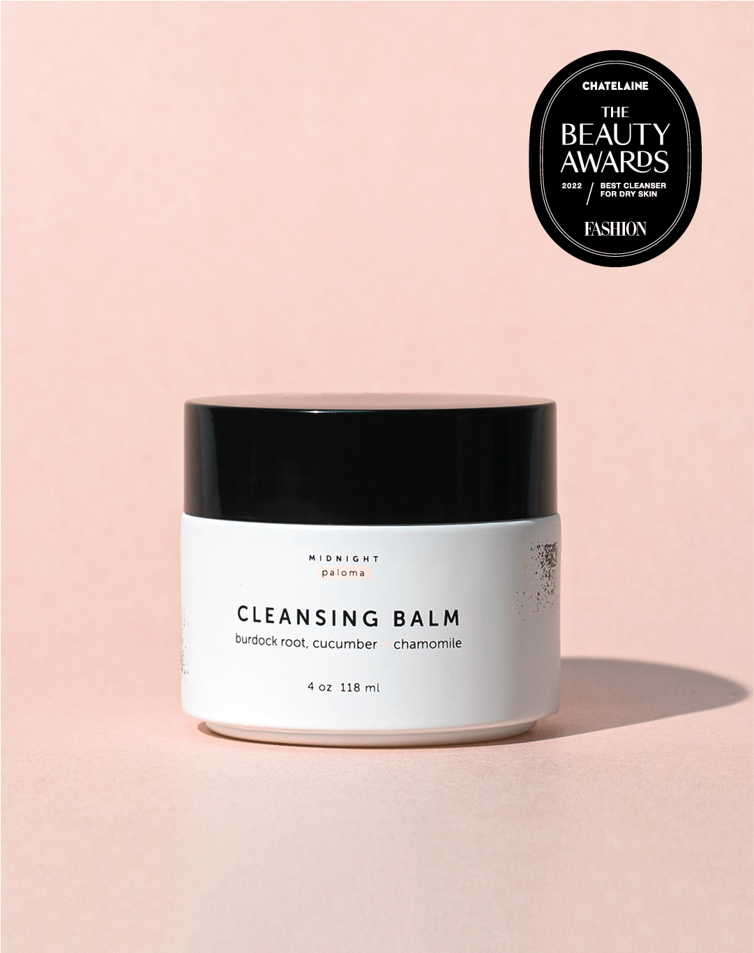 Cleansing balm jar with 'The Beauty Awards' badge on a pink background
