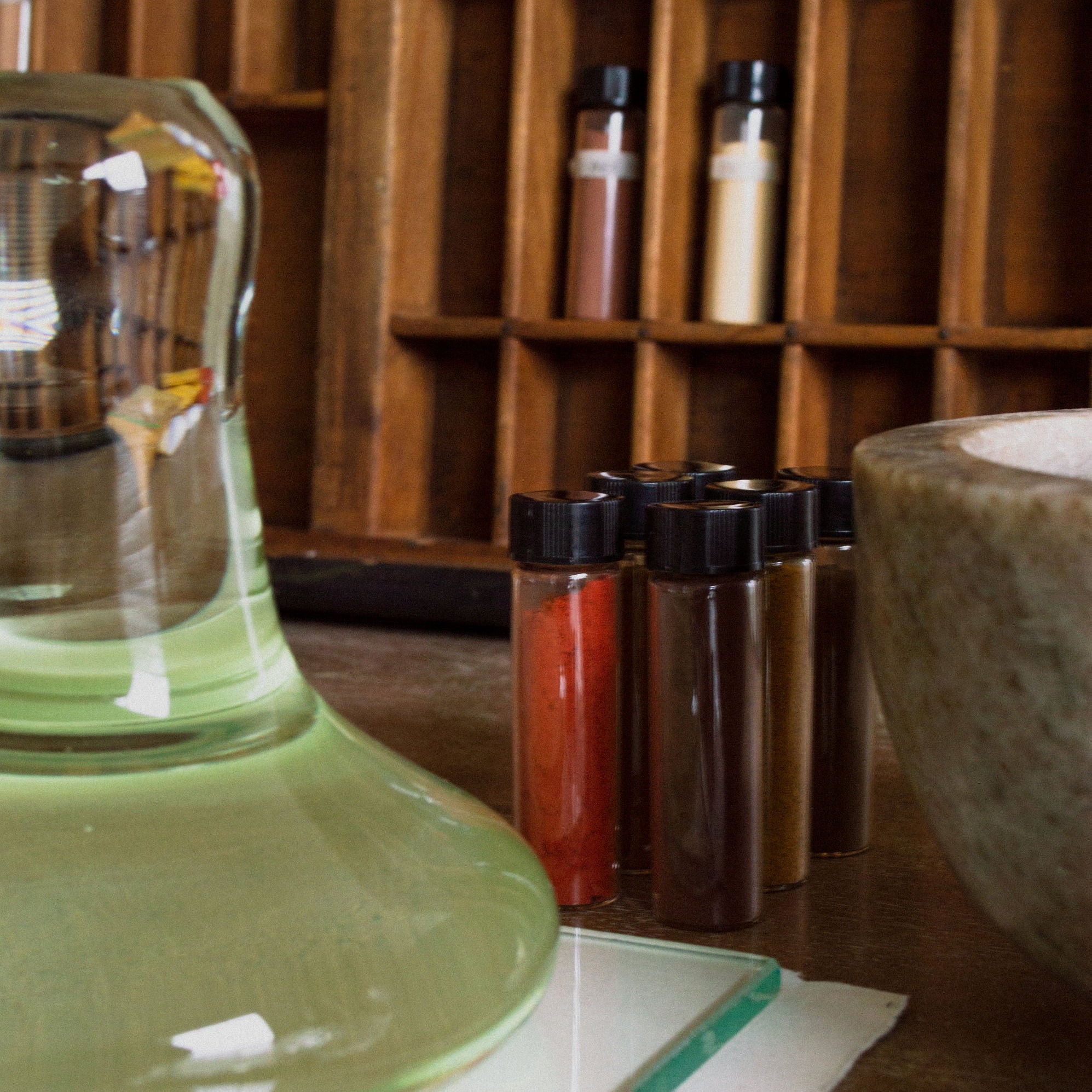 Spices and a Clear Glass Paint Muller  on a wooden shelf