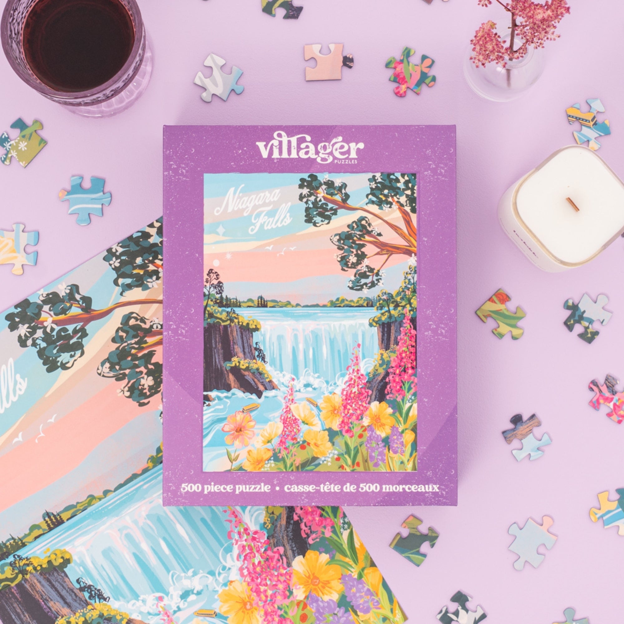 Villager puzzle box Niagara Falls | 500-Piece Puzzle for Adults with a scenic design on a pink background with puzzle pieces.