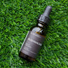 OC Beauty Bottle of Bushwacker beard oil on grass