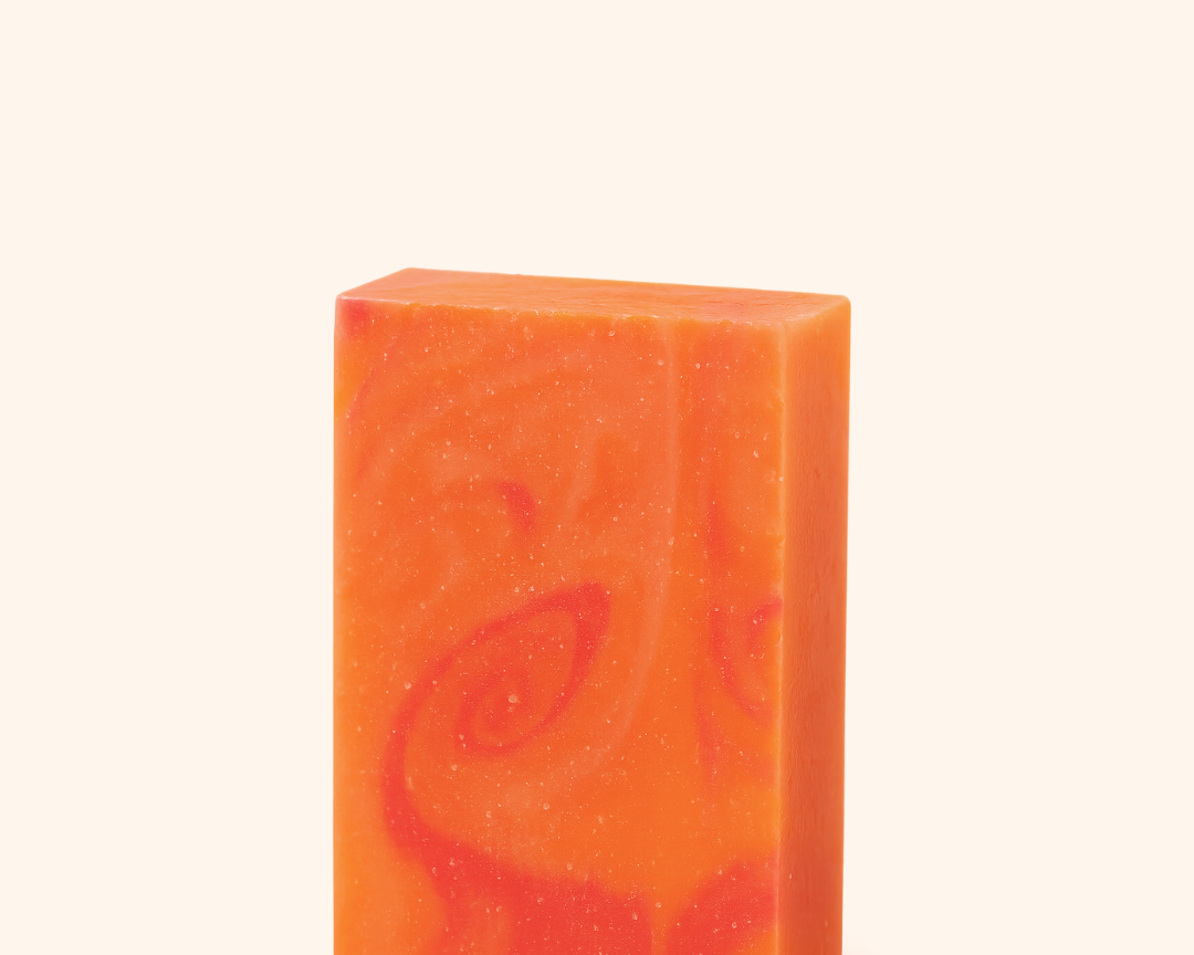 Orange soap bar with a leaf design on a white background