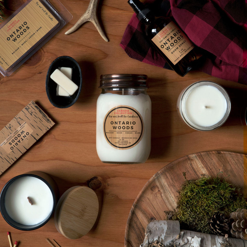 Collection of candles and products with 'Ontario Woods' branding on a wooden surface.