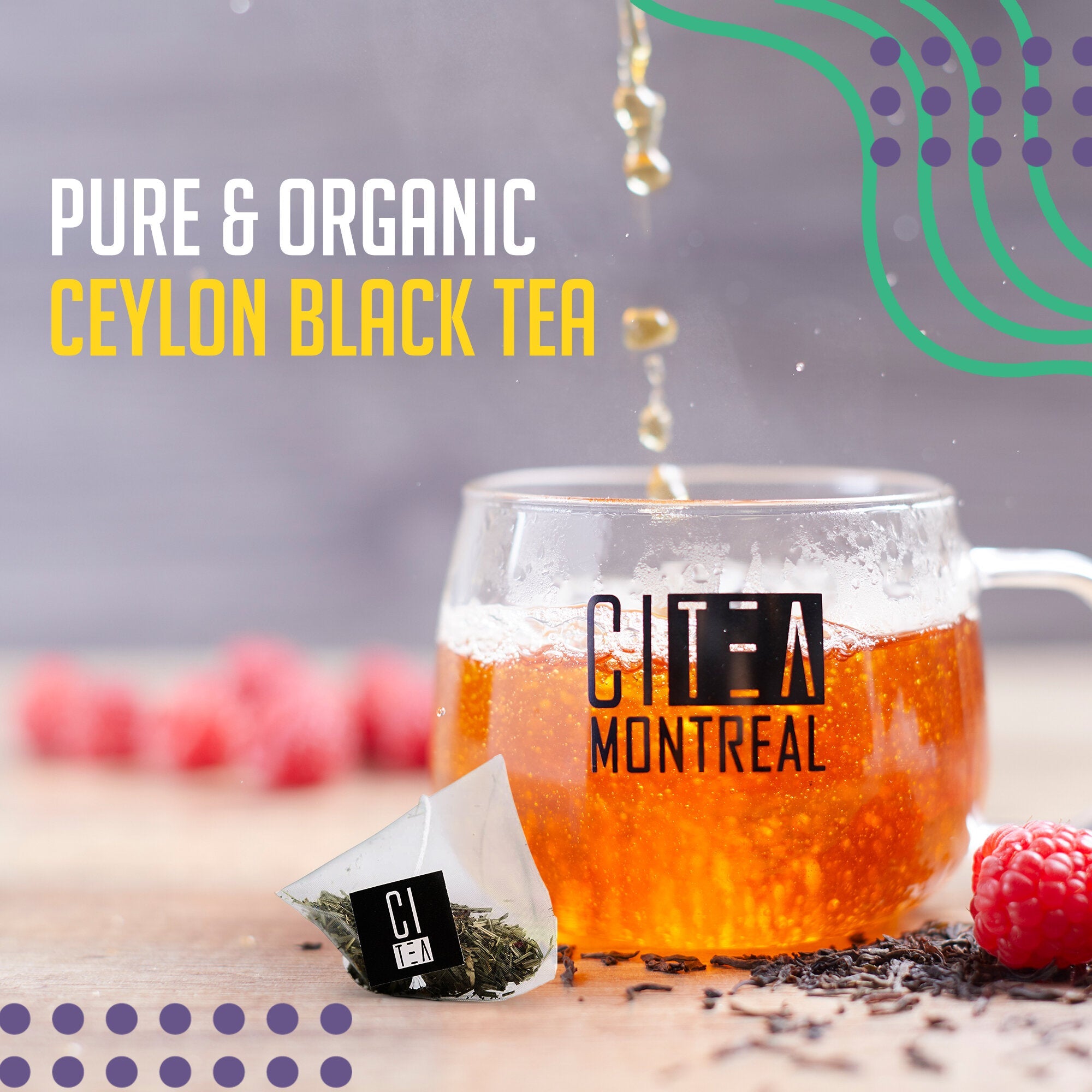 Ceylon Black Tea being poured into a glass mug with tea bag and raspberries on a wooden surface.