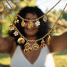 Woman holding a Coastal Crush Necklace with various charms made by Pinky Mimosa