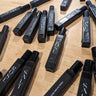 Black 10ml perfume roll on bottles with visible branding on a wooden surface