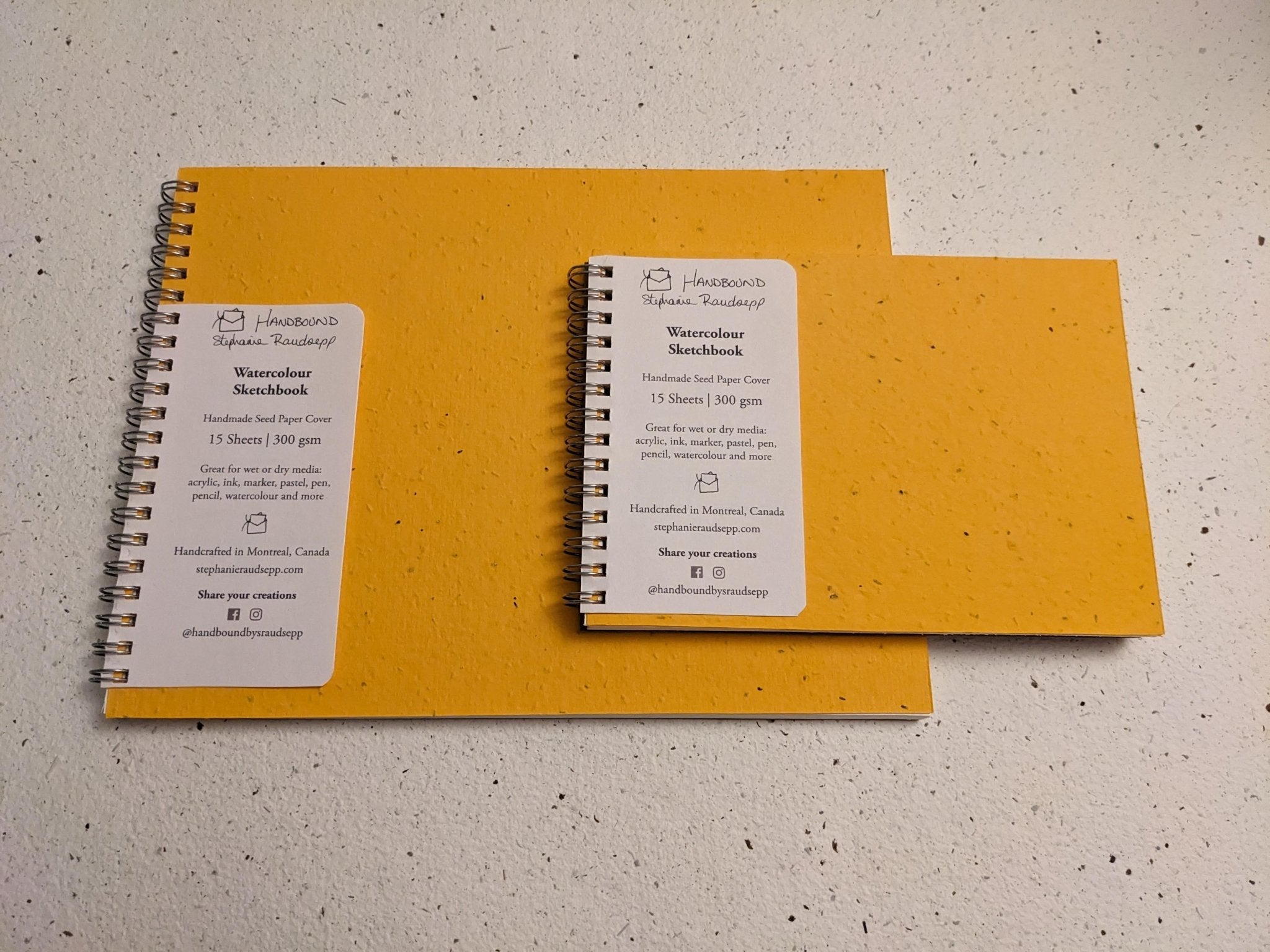 Two yellow notebooks with spiral binding on a textured surface Large Plantable Watercolour Sketchbook by Creative Artifacts HQ