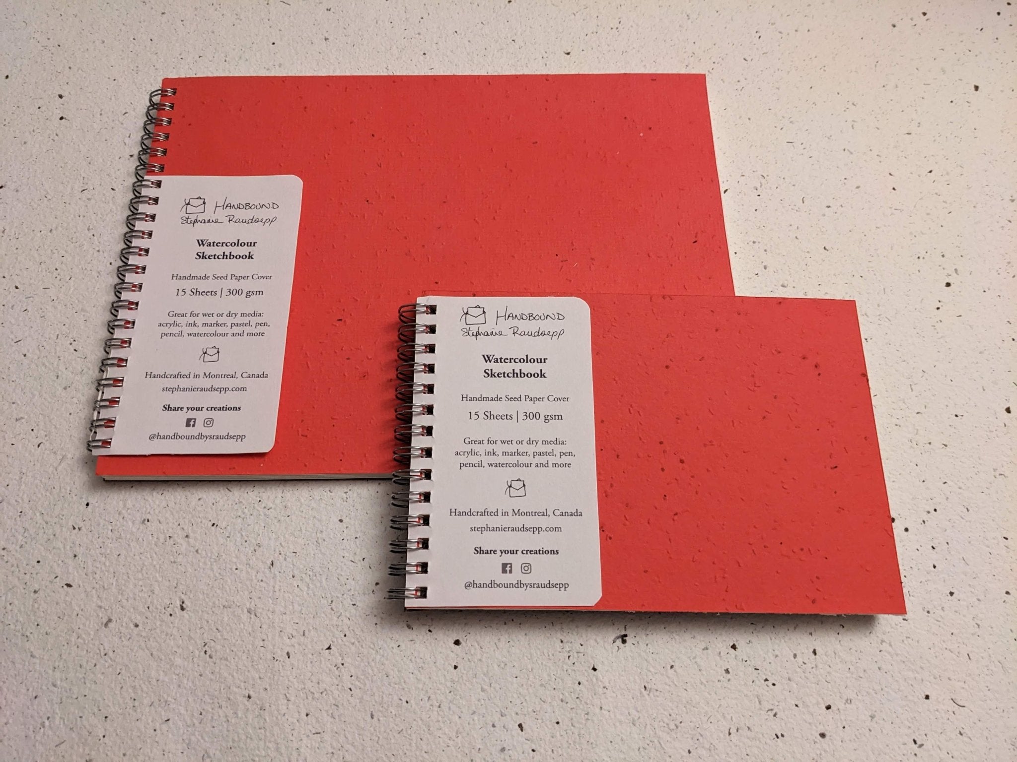 Two red notebooks with spiral binding on a speckled surface Large Plantable Watercolour Sketchbook by Creative Artifacts HQ