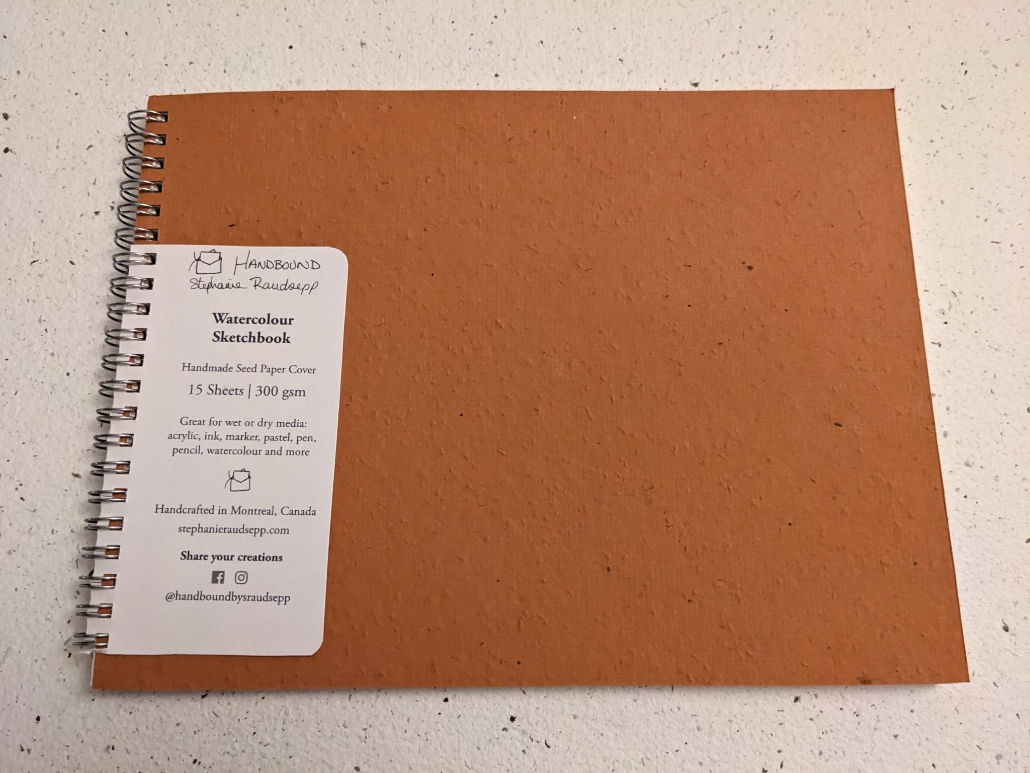Brown sketchbook with a label on a light gray background Plantable Watercolour Sketchbook by Creative Artifacts HQ