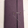 Purple notebook with a button closure on a light grey background Creative Artifacts HQ plantable 
