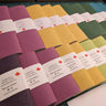 Color swatches with labels on a hand stitched plantable paper notebook on a light grey background Creative Artifacts HQ