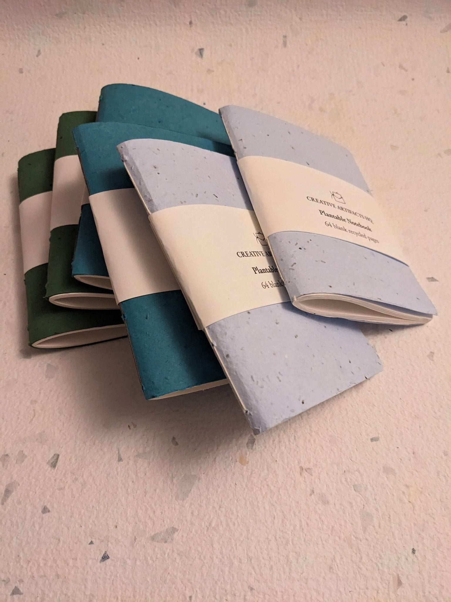 Set of three notebooks with different color combinations on a textured Creative Artifacts HQ plantable handmade surface