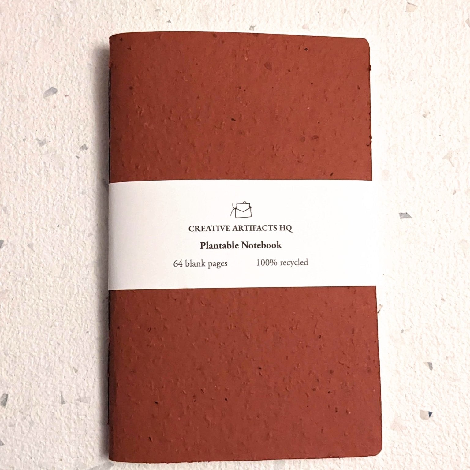 Brown notebook with a white label on a light beige background Creative Artifacts HQ plantable handmade