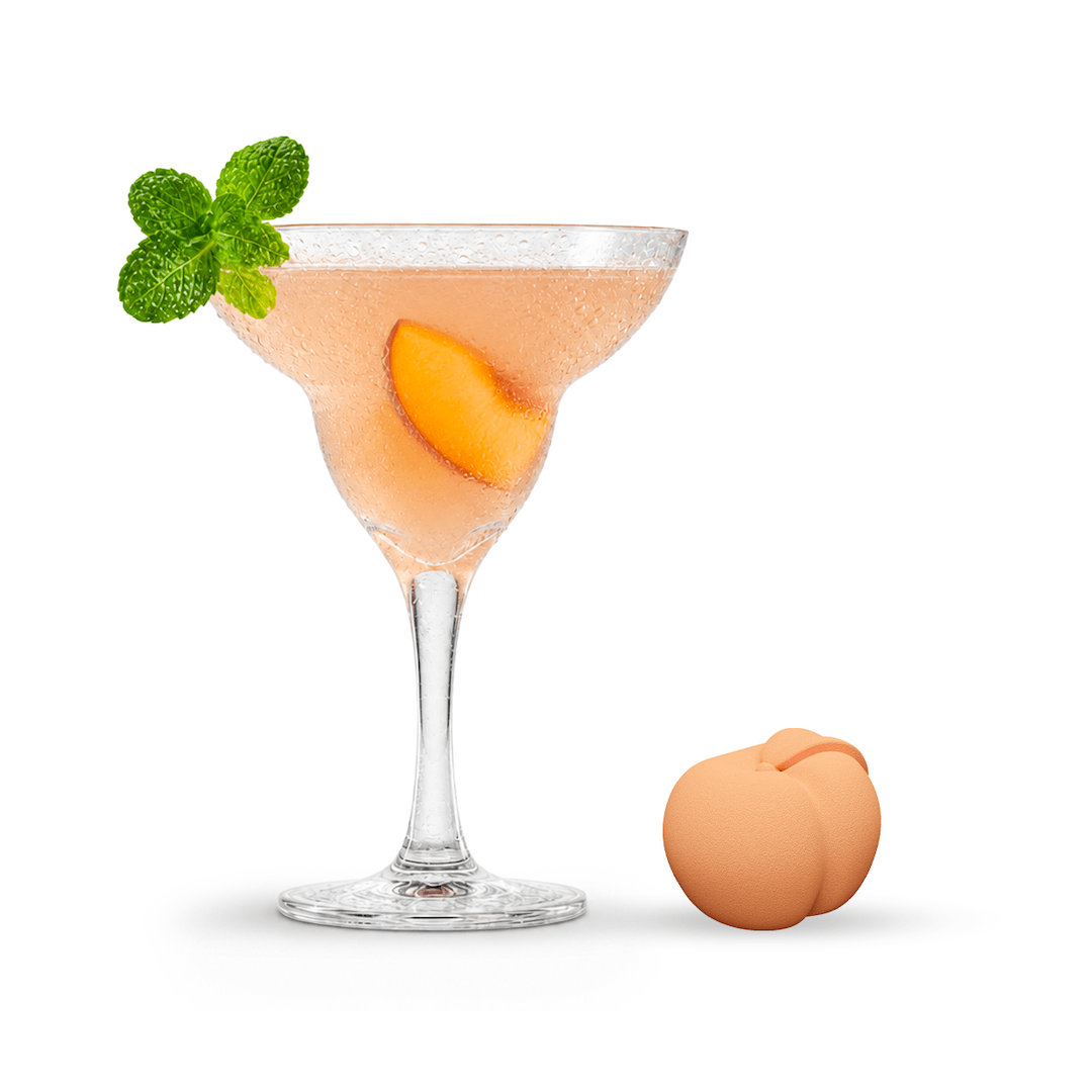 Poseidn Peach Margarita Mocktail with peach slice and mint leaf in a glass, accompanied by a whole peach on a white background