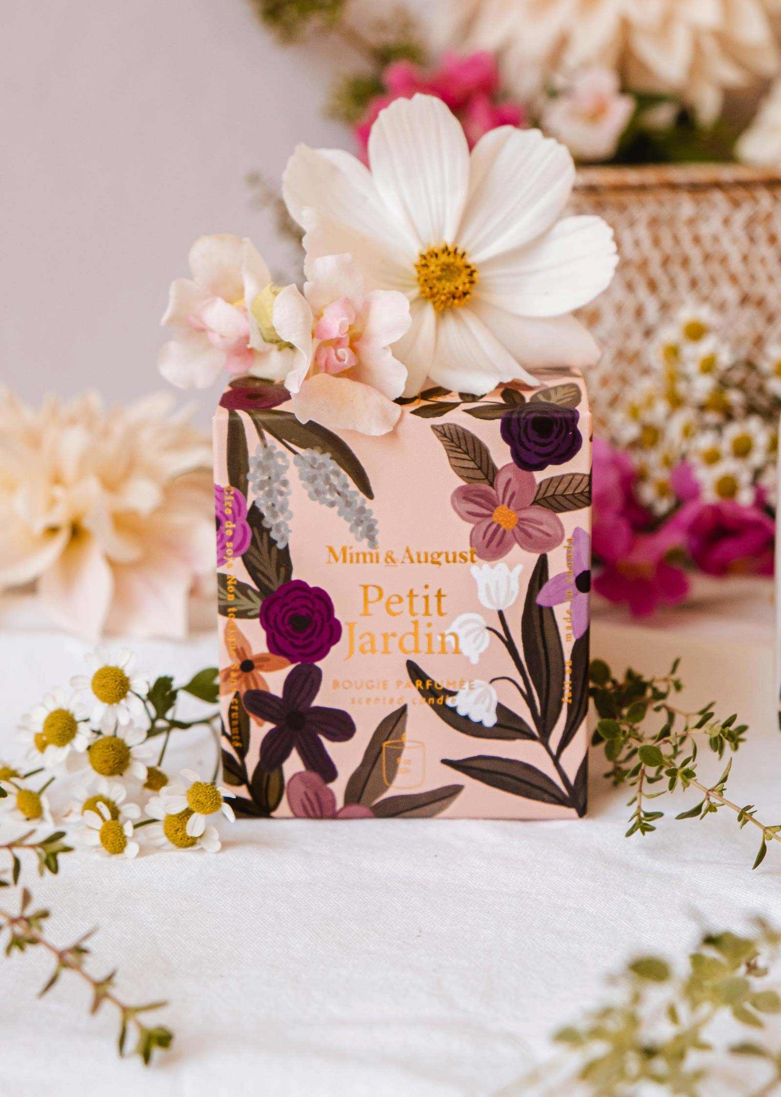 Floral soap bar with packaging on a white surface surrounded by flowers