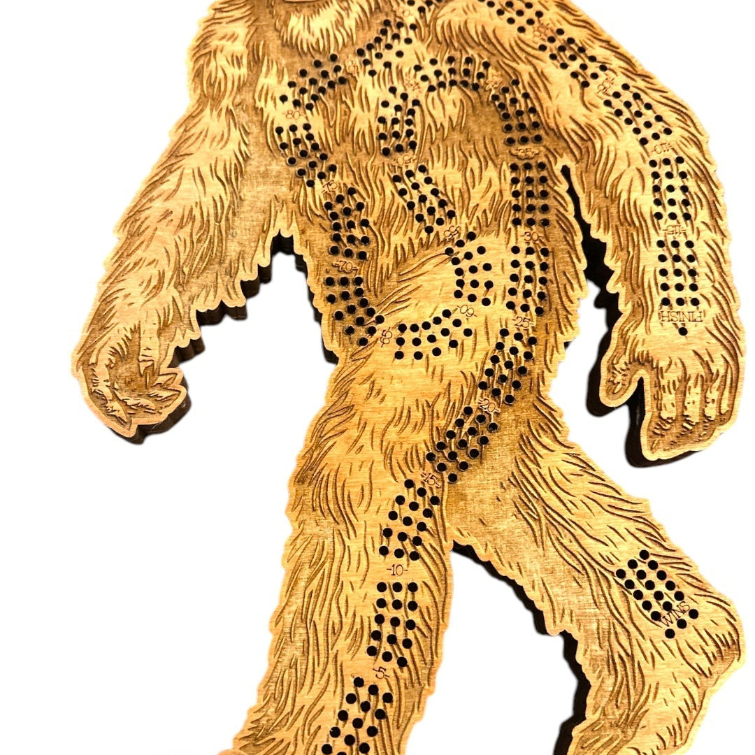 A hand carved wooden Sasquatch Crib board shaped like a walking sasquatch, featuring pre-drilled peg holes for toy storage, shown on a white background 