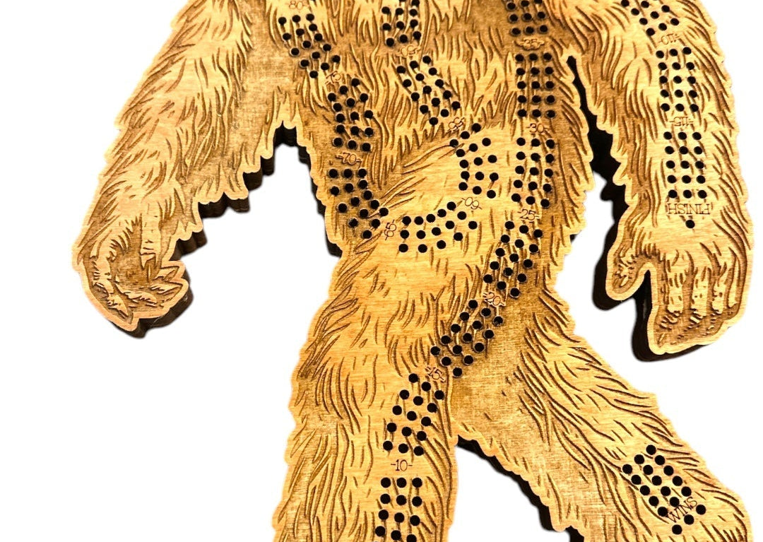 A hand carved wooden Sasquatch Crib board shaped like a walking sasquatch, featuring pre-drilled peg holes for toy storage, shown on a white background 