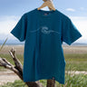 Blue t-shirt with a wave design on a wooden hanger against a natural background