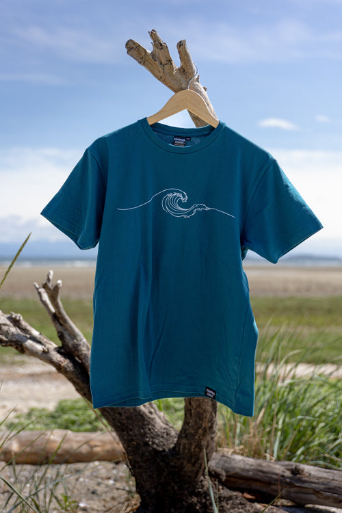 Blue t-shirt with a wave design on a wooden hanger against a natural background