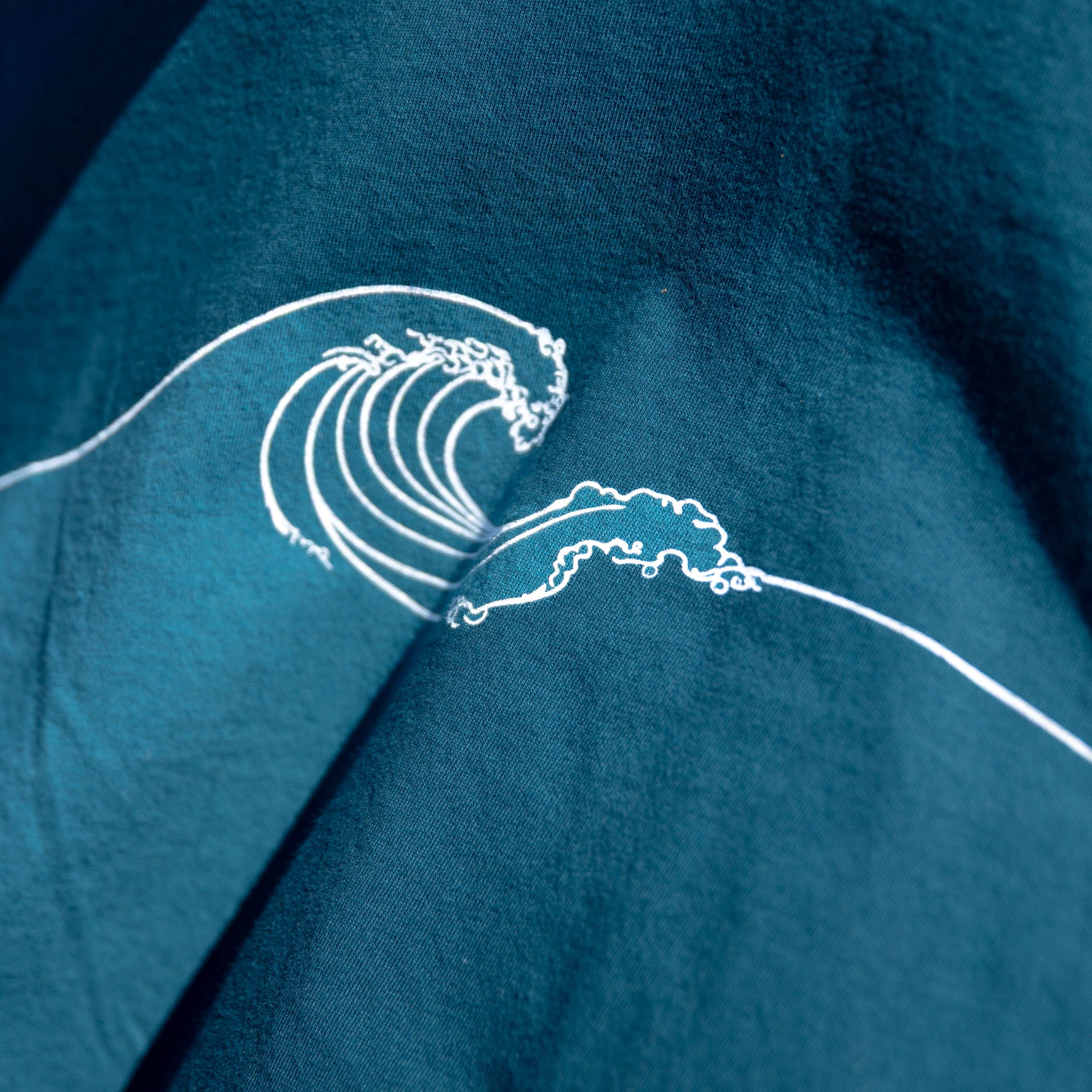 Blue t-shirt with a white wave design on a dark background