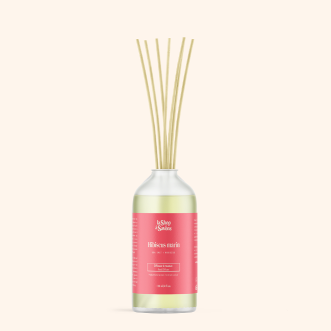 Reed diffuser with a pink label on a white background