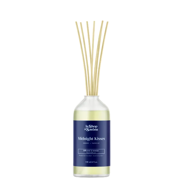 Diffuser with reeds labeled 'Midnight Kisses' on a light beige background