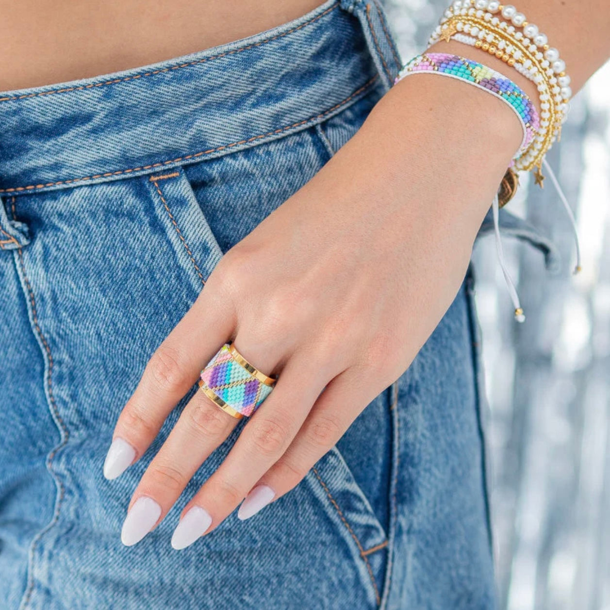 Close-up of a hand wearing a Miyuki Ring - Rainbow from Pinky Mimosa