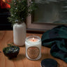 Stopandsmellthecandles Rocky Mountain Juniper soy candle – 8 oz clear glass jar, lit beside juniper branches
