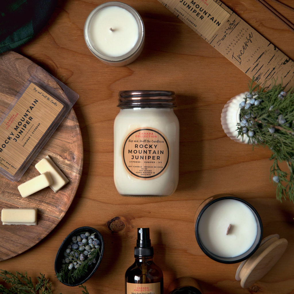 Candle and product set on a wooden surface with 'Rocky Mountain Juniper' branding.
