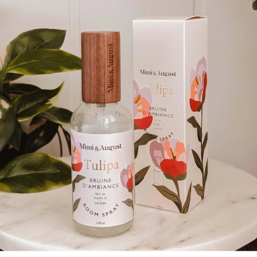 Mimi & August Tulipa room spray bottle and packaging on a marble surface with a plant in the background.