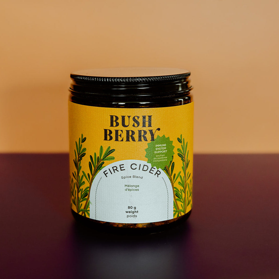 Jar of Bush Berry Fire Cider with a yellow label on a gradient background