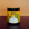 Jar of Bush Berry Fire Cider with a yellow label on a gradient background