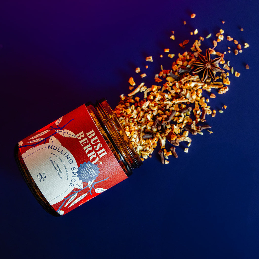 Open jar of Bush Perry Mulling Spice with spices spilling out on a dark background