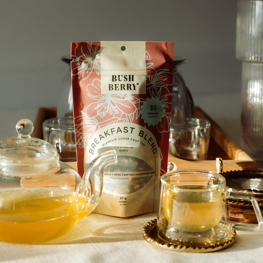 Tea package labeled 'Bush Berry Breakfast Blend' with a teacup and teapot on a wooden tray.