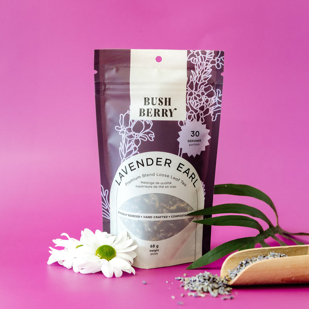 Tea package labeled 'Lavender Earl' from 'Bush Berry' on a pink background with a white flower and green leaves.