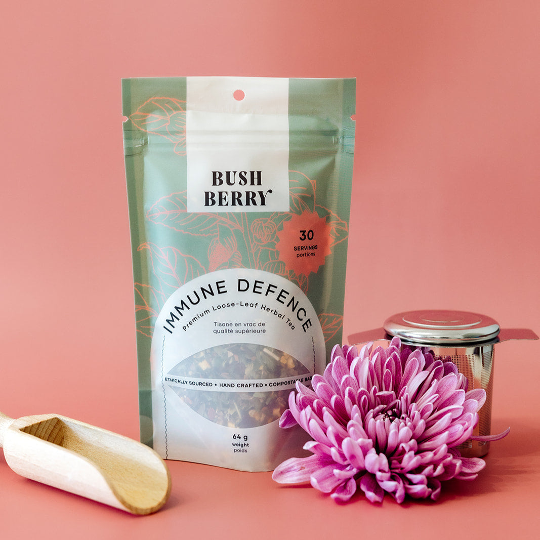 Tea package labeled 'Bush Berry Immune Defence' with a pink flower on a pink background