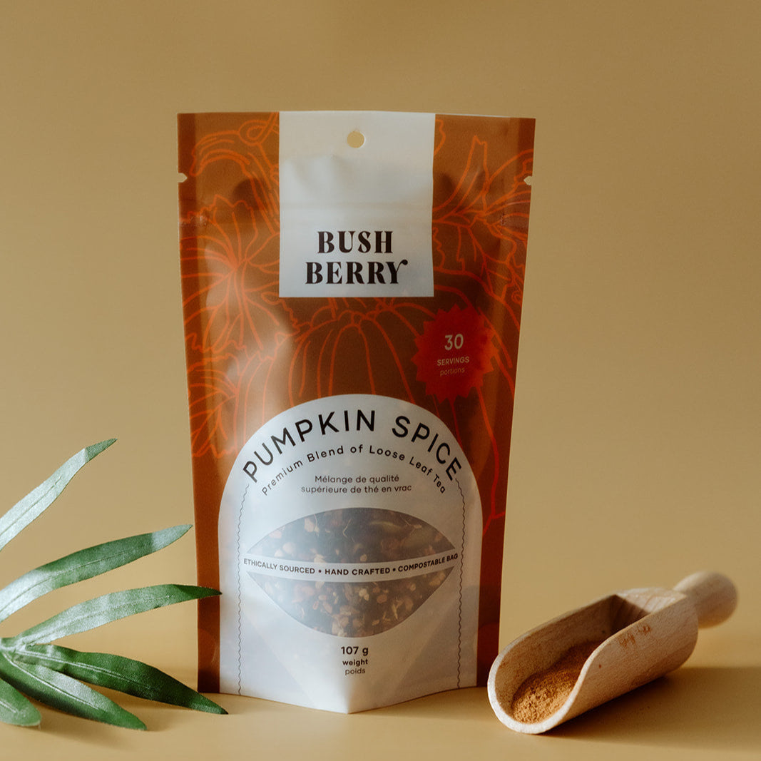 Organic Pumpkin Spice Tea package with a wooden scoop and leaves on a beige background