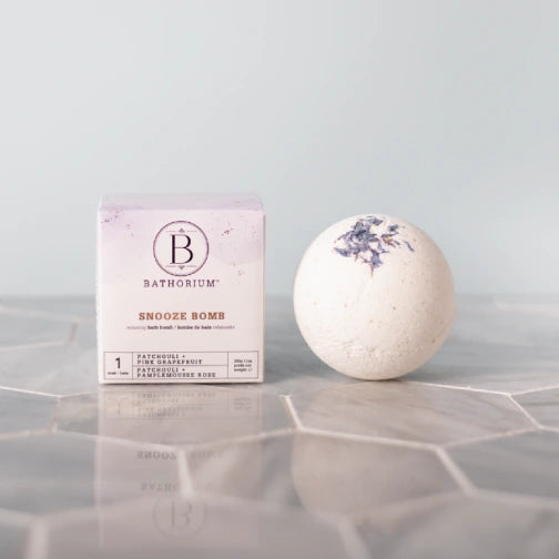 Bathorium Snooze bomb Calming floral bath bomb for evening rituals  on a reflective surface with a light gray background