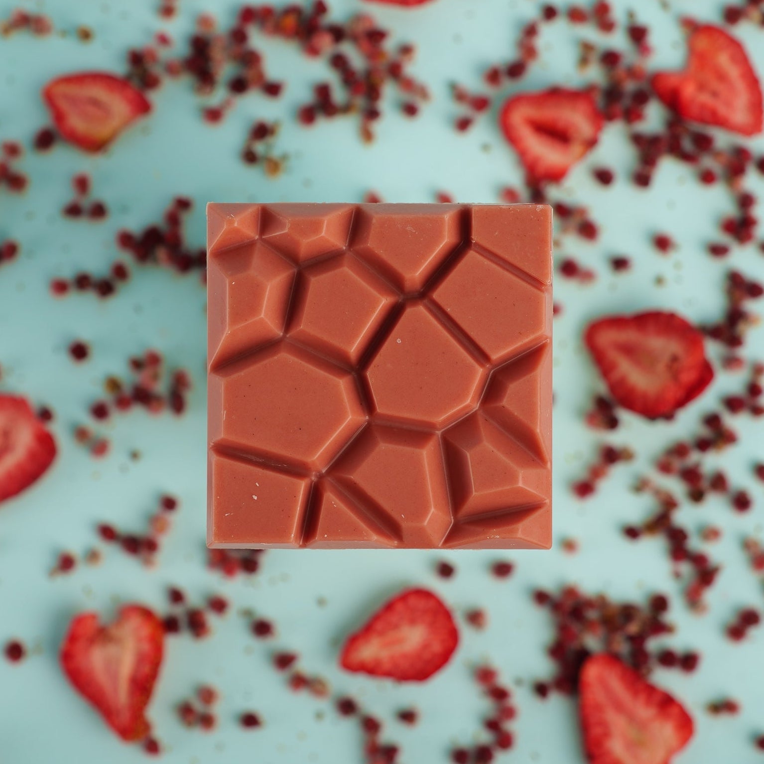 Chocolate mold with geometric pattern on a background of strawberries
