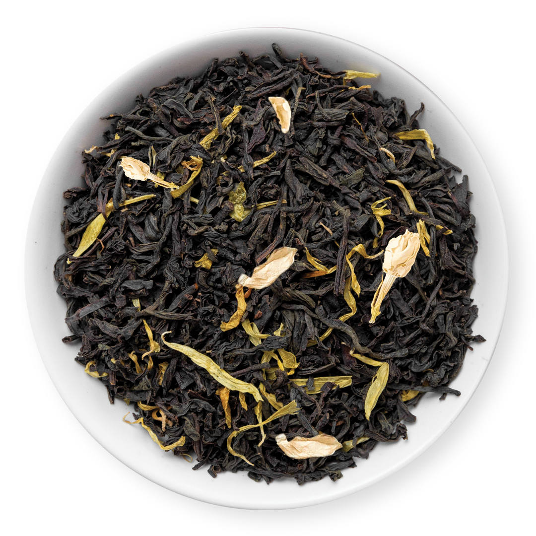 Black tea leaves in a white bowl on a white background