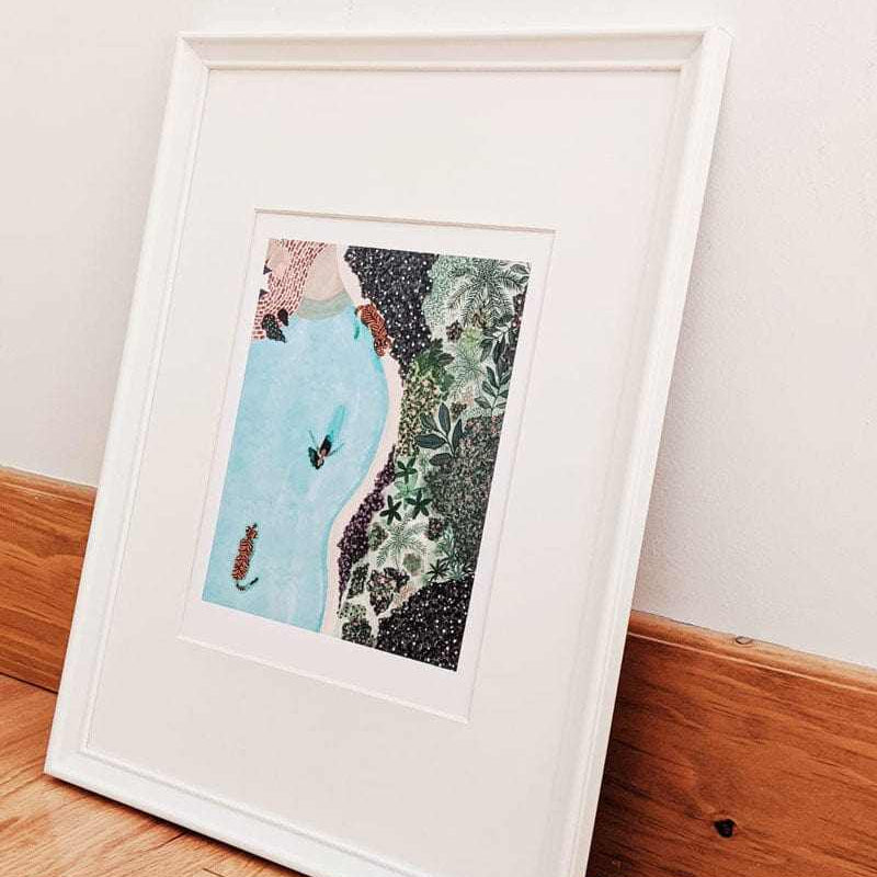 Framed artwork on a wooden floor with a white wall background