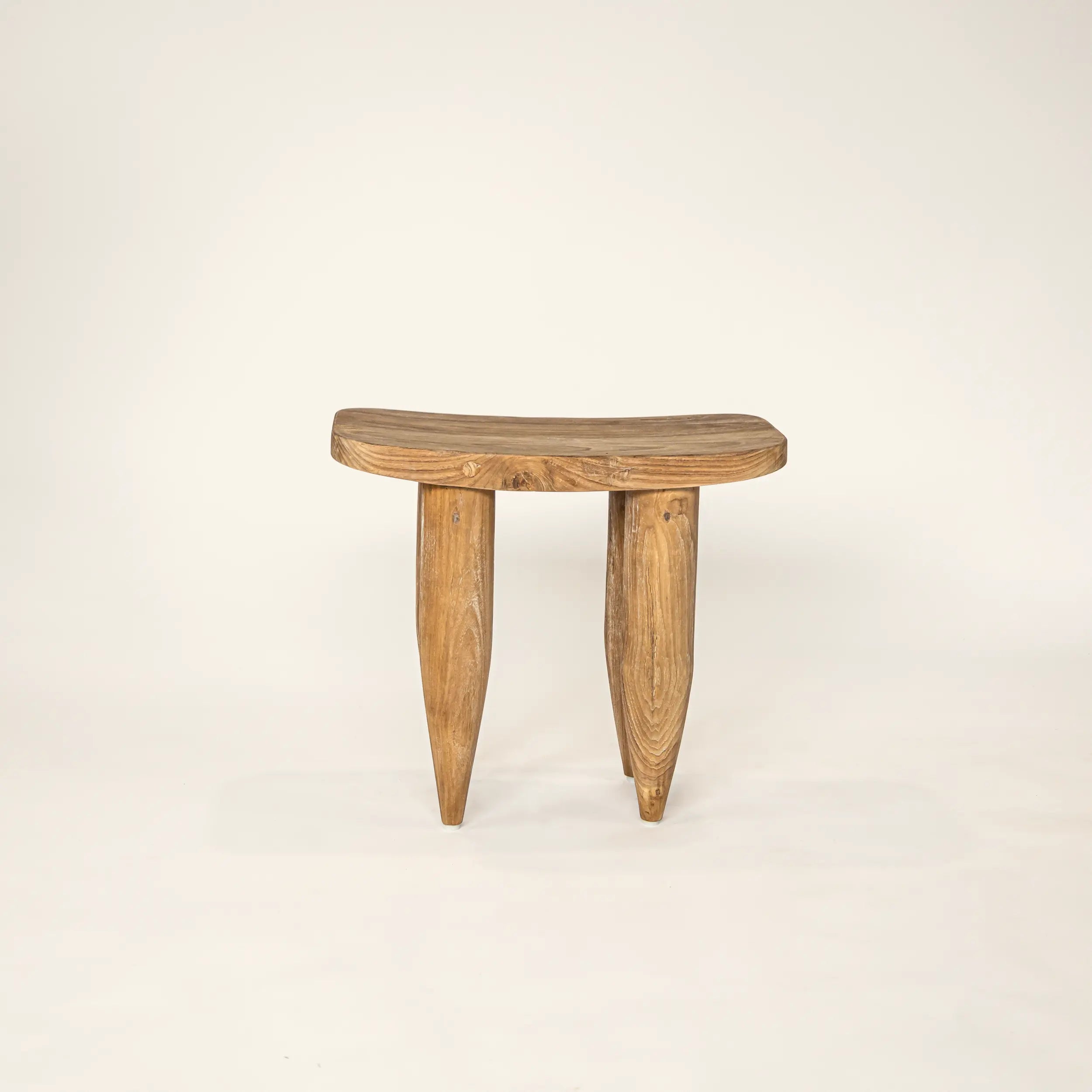 Wooden stool with three legs on a beige background