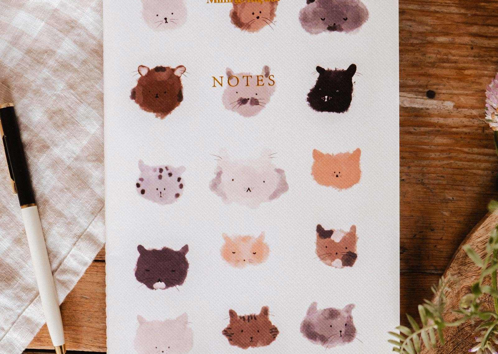 Notebook with animal illustrations on a wooden surface mimi-and-august