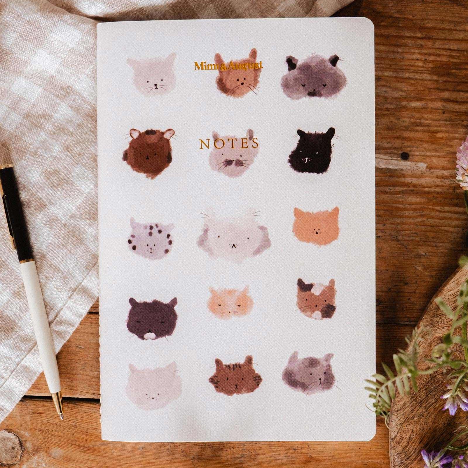 Notebook with animal illustrations on a wooden surface mimi-and-august