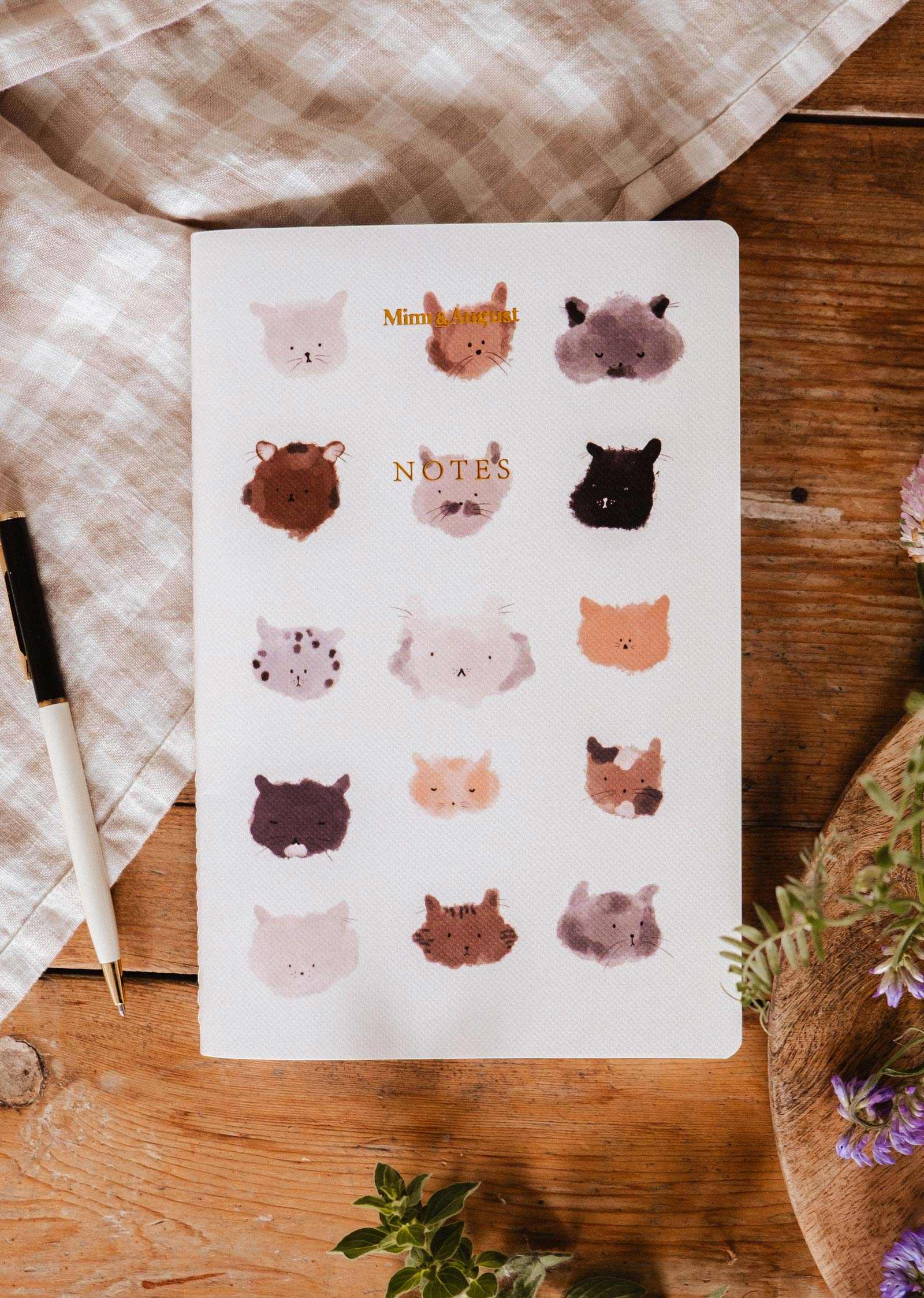Notebook with animal illustrations on a wooden surface mimi-and-august